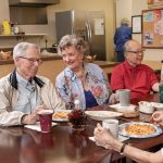 group of seniors sitting around table and discussing myths around aging