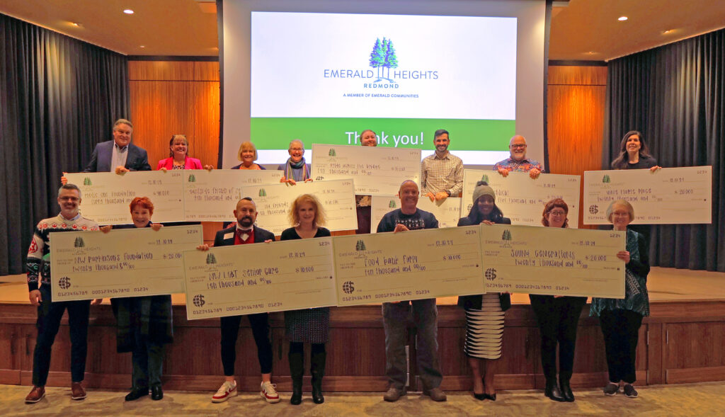Emerald Heights residents and local nonprofit representatives holding donation checks during the annual Social Accountability awards ceremony at Emerald Heights in Redmond, Washington.