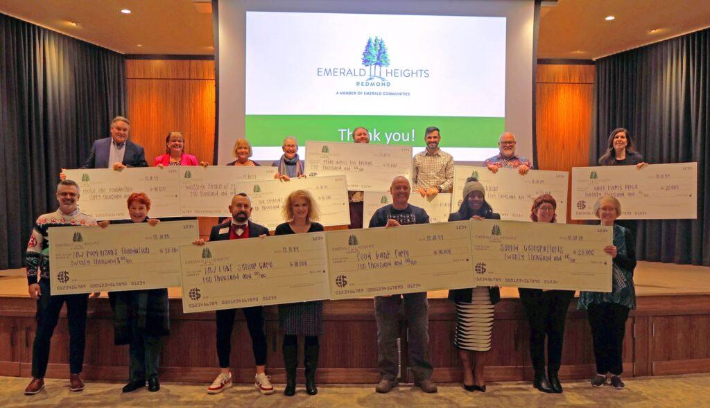 Emerald Heights residents and local nonprofit representatives holding donation checks during the annual Social Accountability awards ceremony at Emerald Heights in Redmond, Washington.