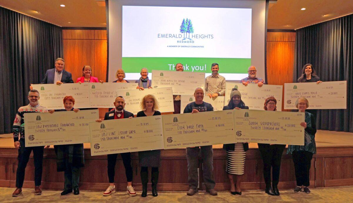 Emerald Heights residents and local nonprofit representatives holding donation checks during the annual Social Accountability awards ceremony at Emerald Heights in Redmond, Washington.
